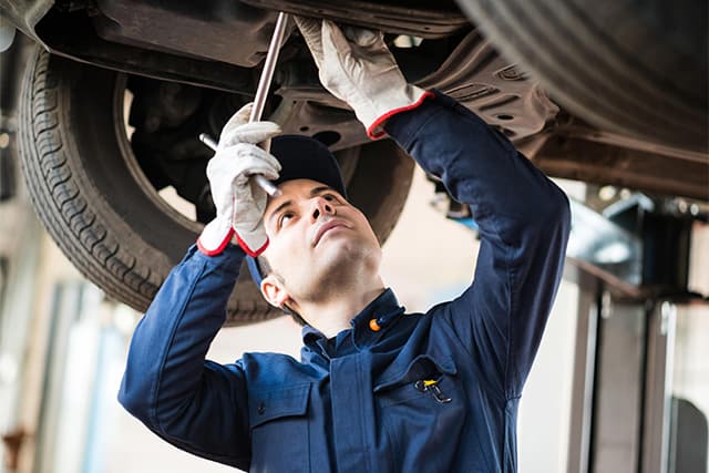 mechanic holding a performance part for a happy customer_0000_mechanic performs inspection on vehicle