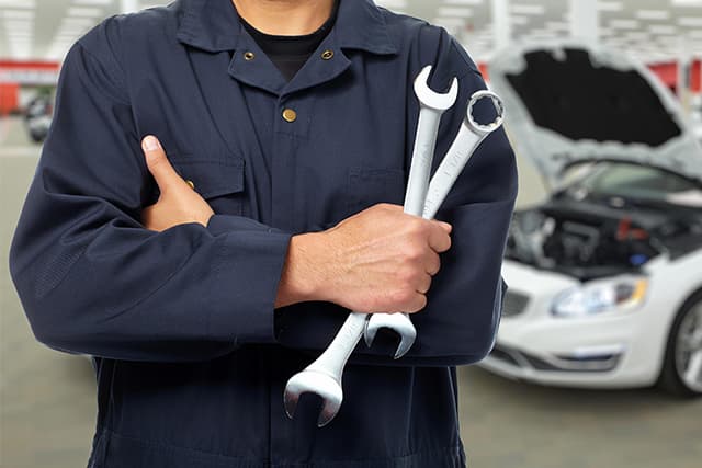 mechanic holding a performance part for a happy customer_0001_mechanic performs repair on a vehicle