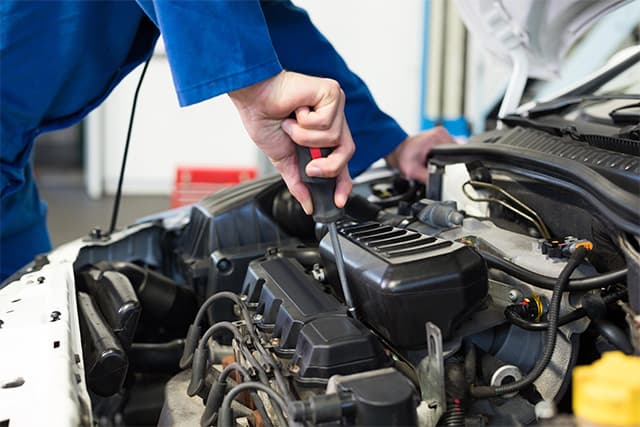 mechanic holding a performance part for a happy customer_0002_mechanic performs routine maintenance at an affordable price